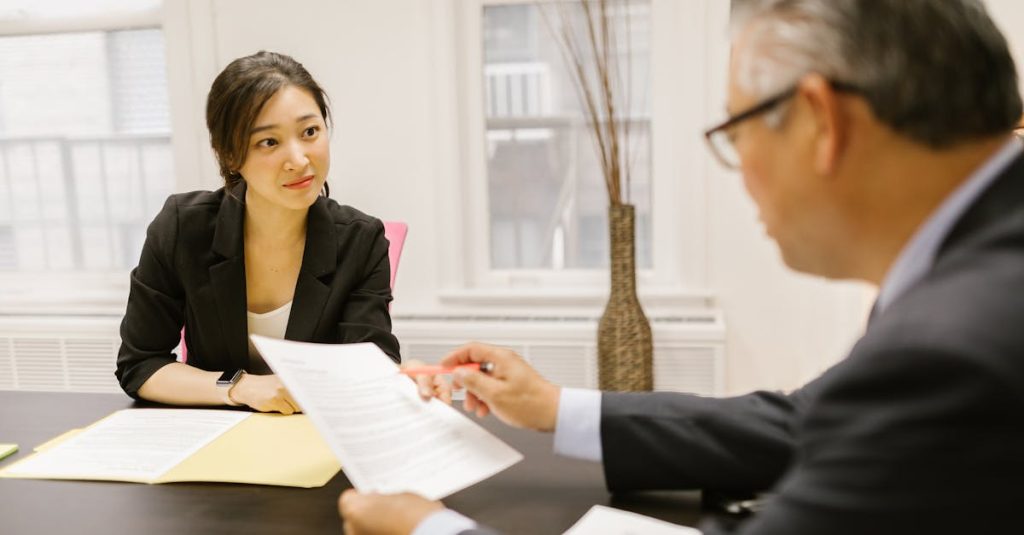 Professional colleagues discussing documents in a modern office setting. Article - 10 business English Mistakes that Japanese business professionals make